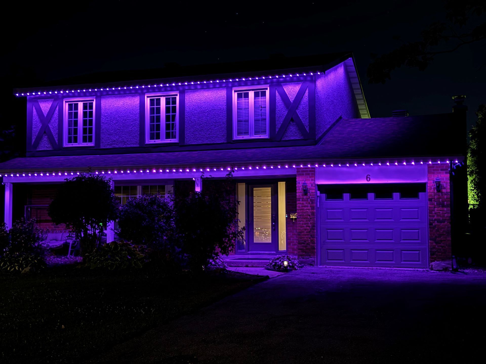 A house is lit up with purple lights at night.
