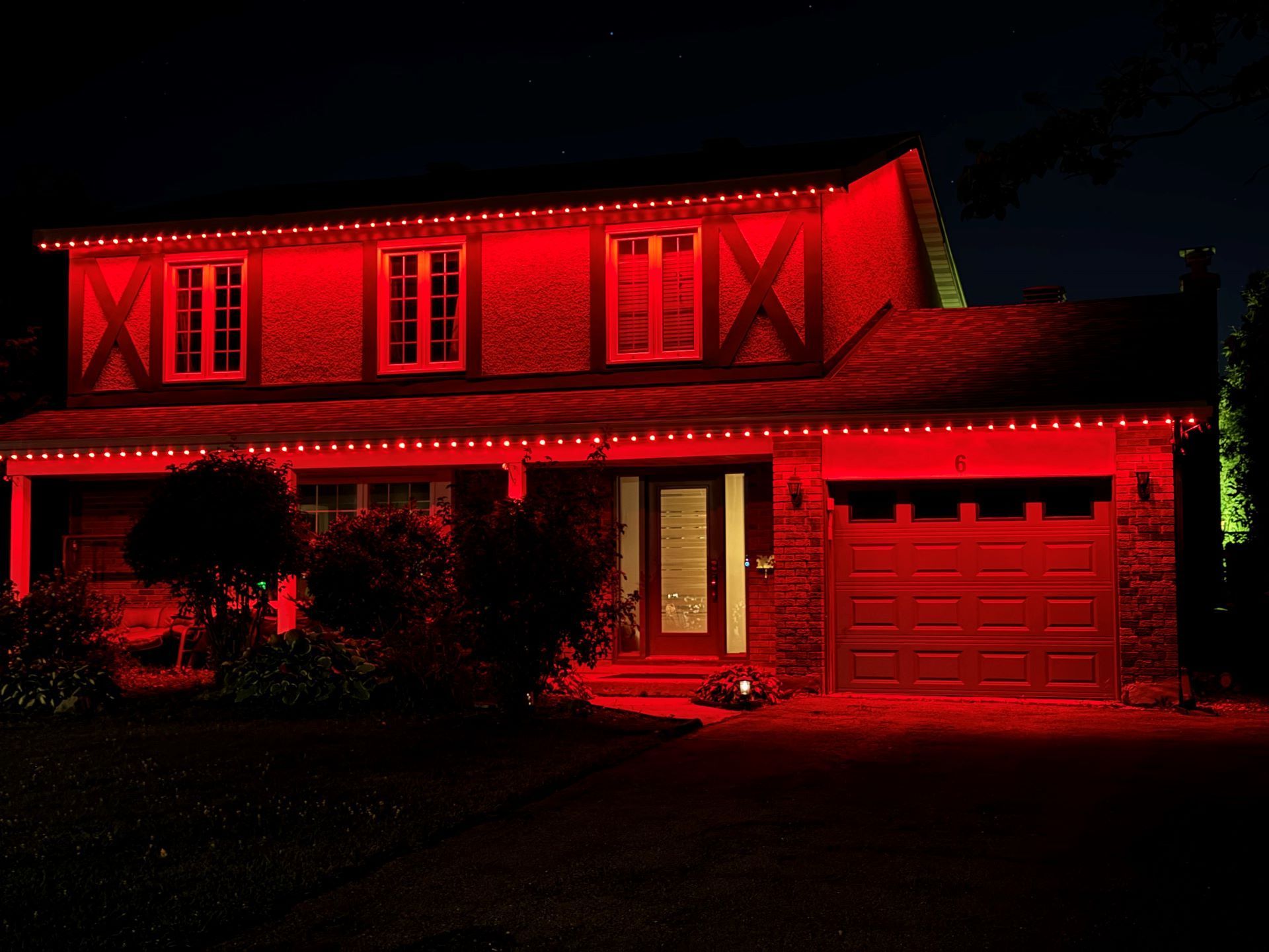 A house is lit up with red lights at night.