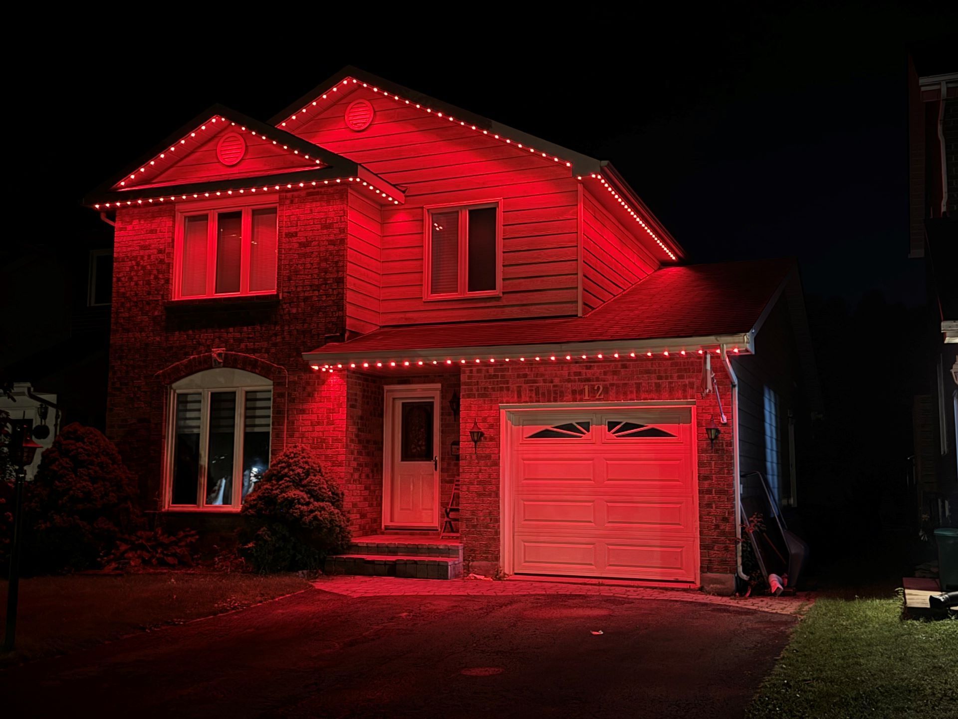 A house is lit up with red lights at night.