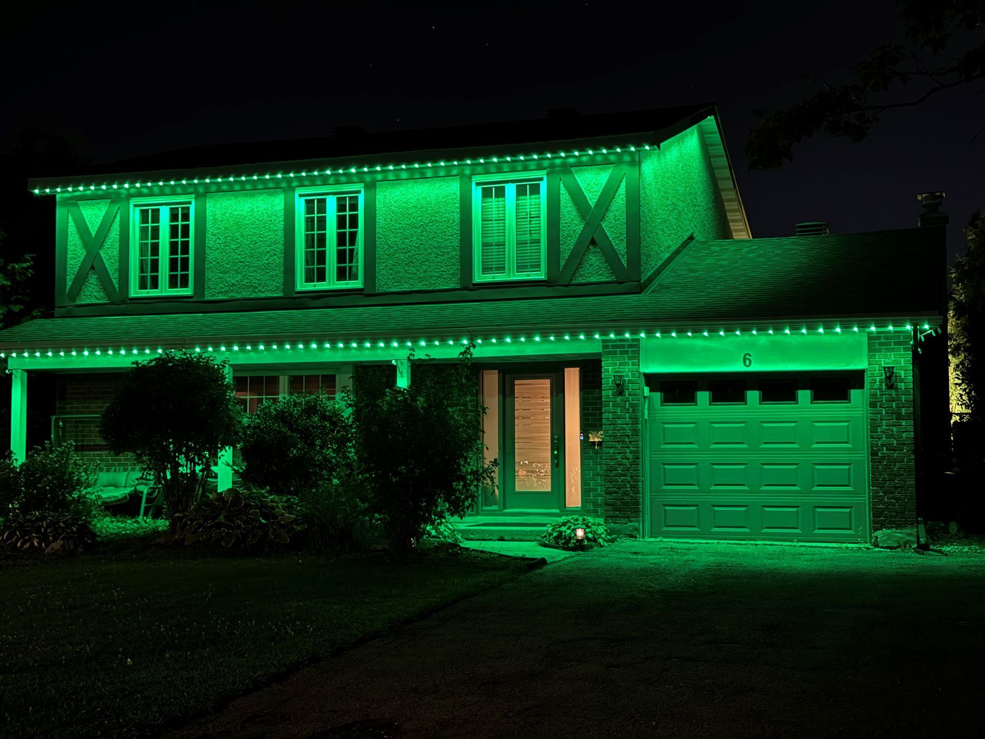 A house is lit up with green lights at night