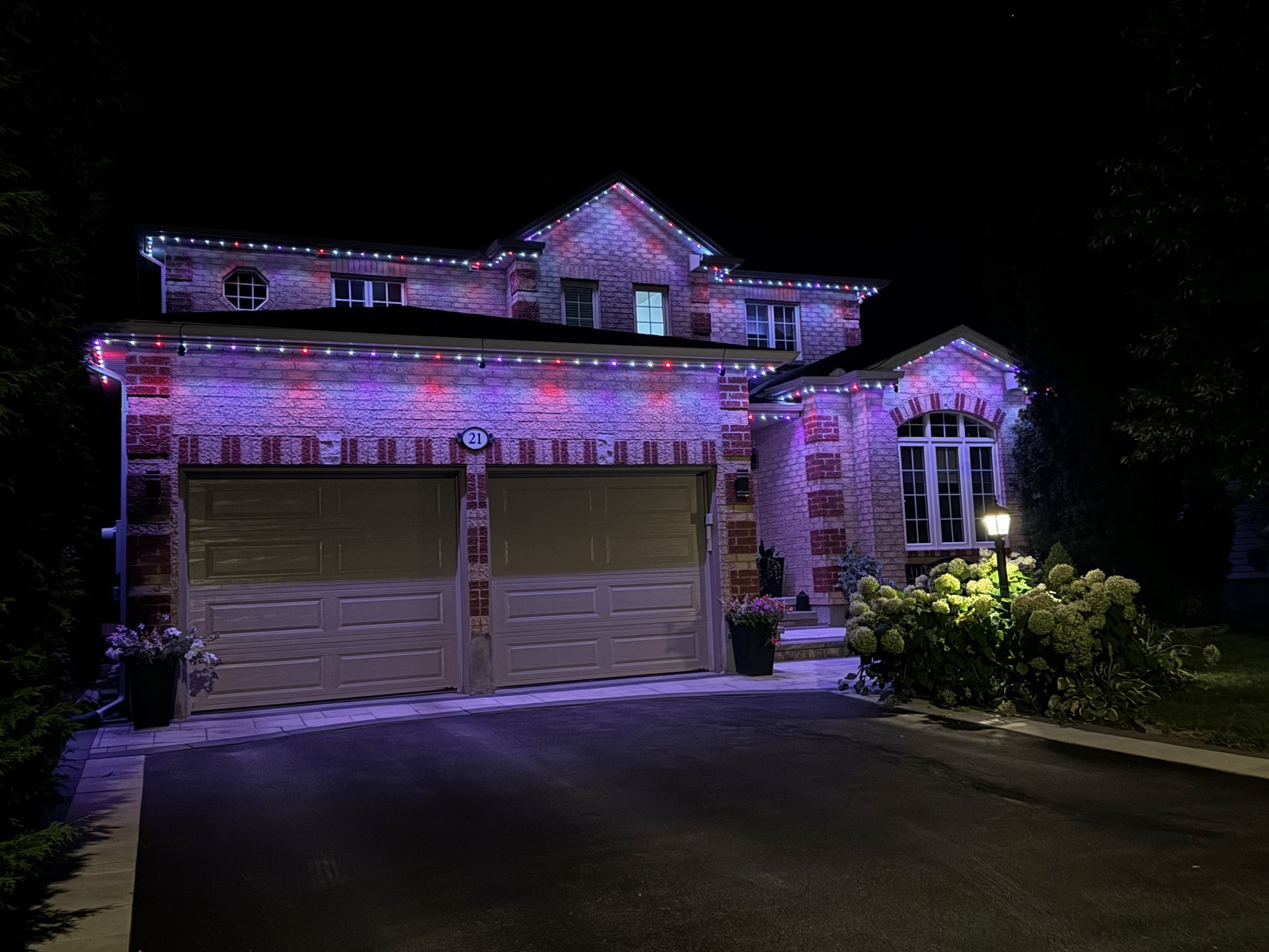 A large house is lit up with christmas lights at night.