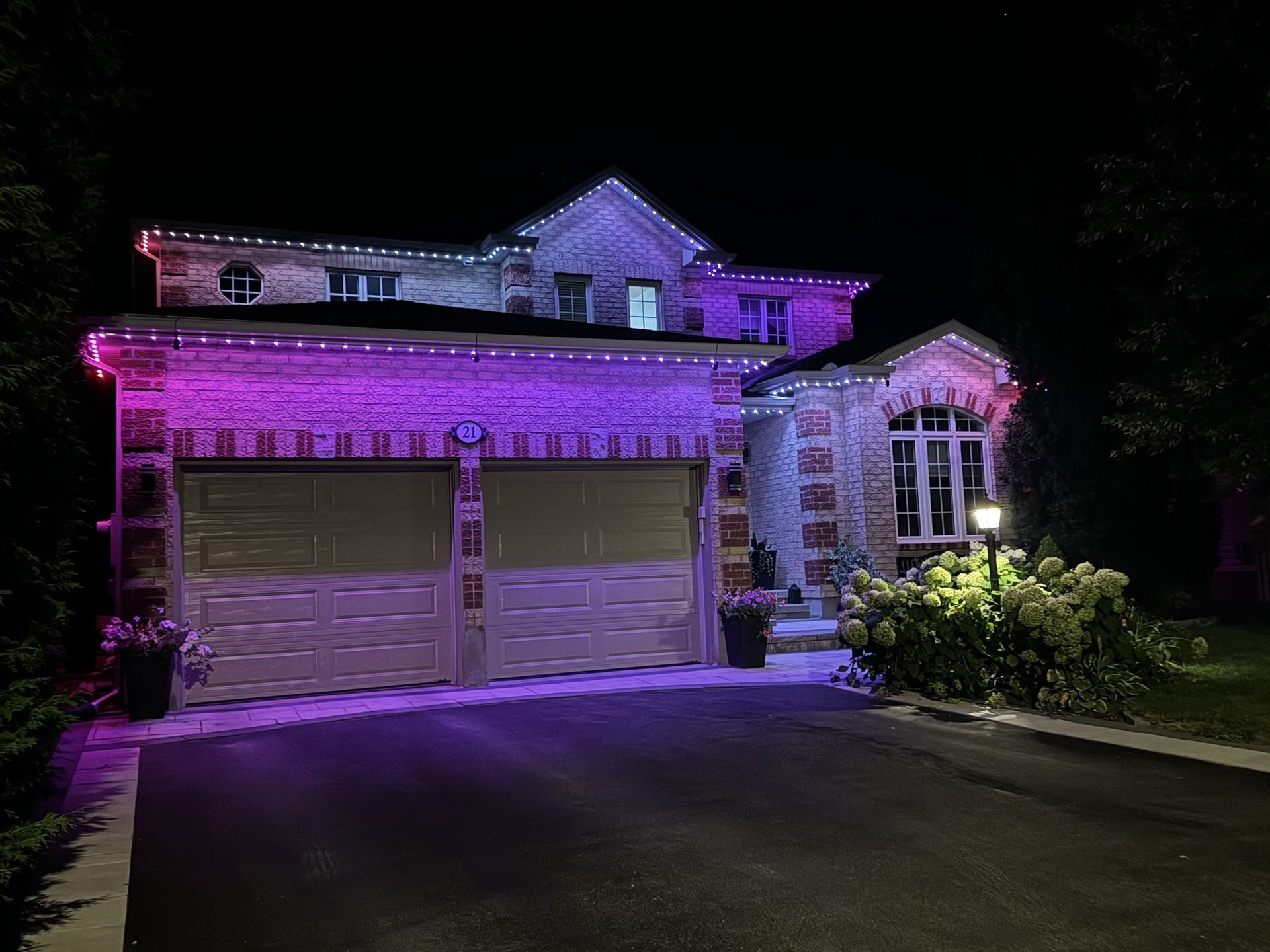A large house is lit up with purple lights at night.