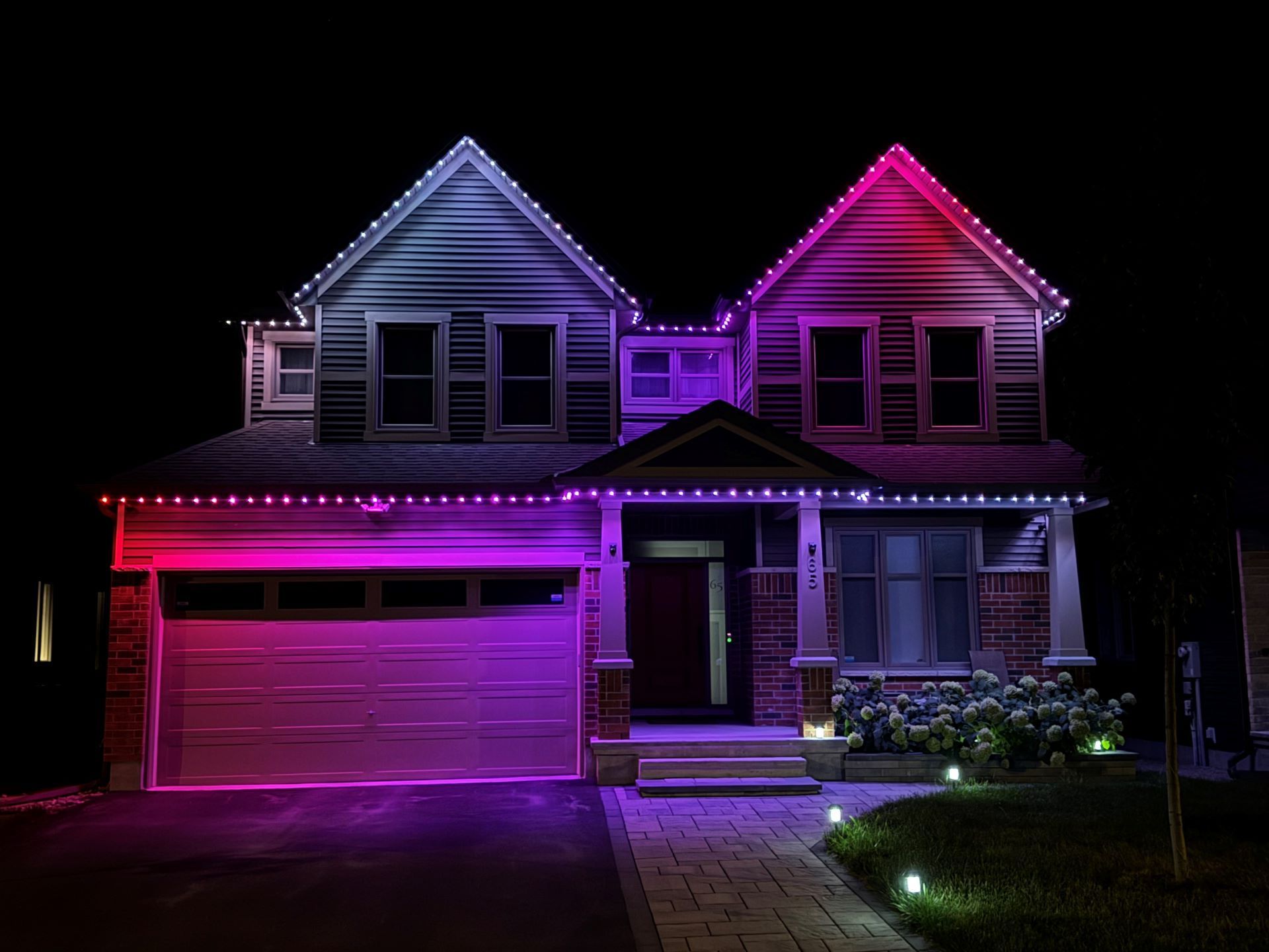 A house is lit up with purple and red lights at night.
