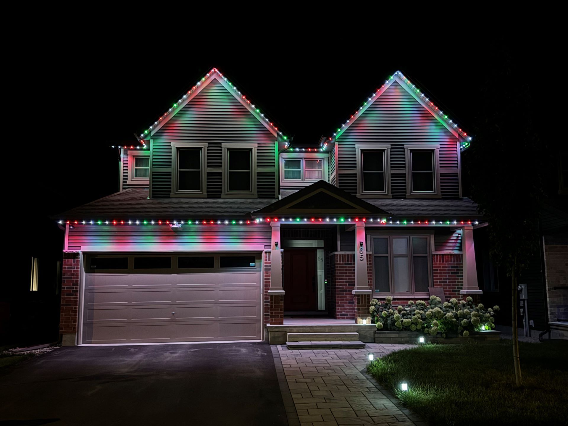 A house is lit up with christmas lights at night.