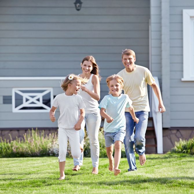 A family is running in front of a house.