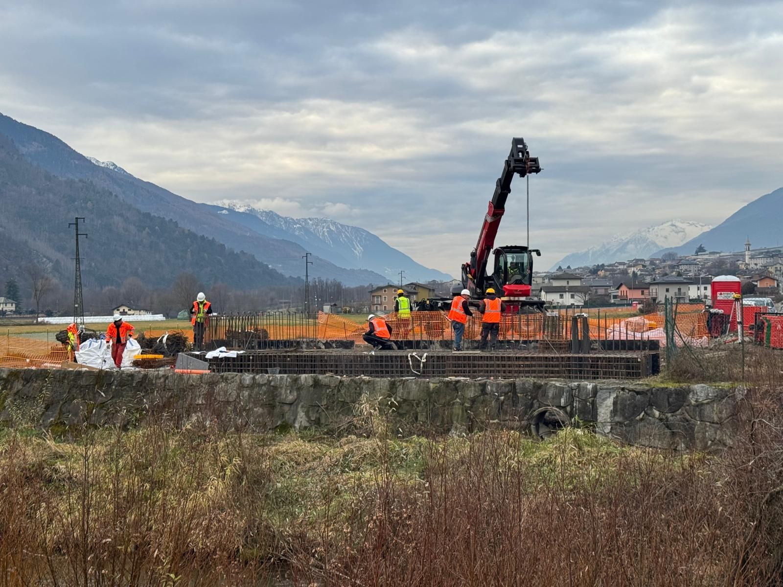 Vista dello skyline della città dalla passerella in legno, acqua in primo piano, cielo nuvoloso.