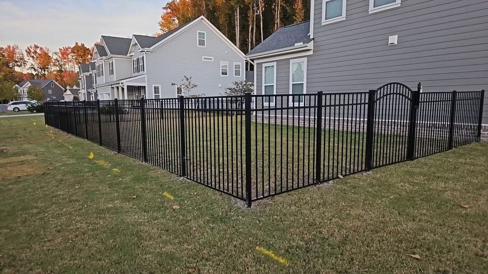 Electric gate opener attached to a white metal gate and concrete post.