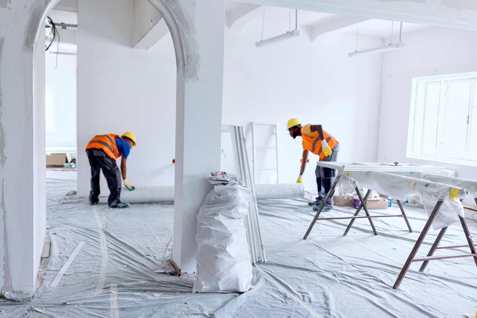 A person is pouring pink paint into a bucket.