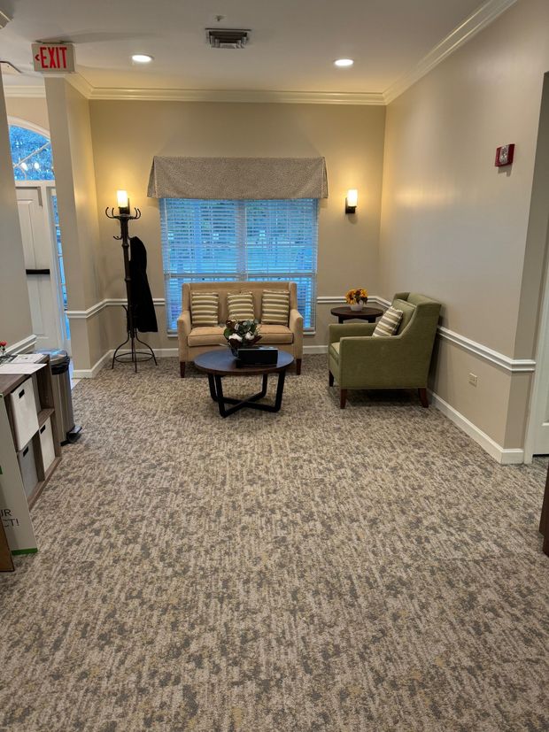 A living room with a couch , chairs , and a table.