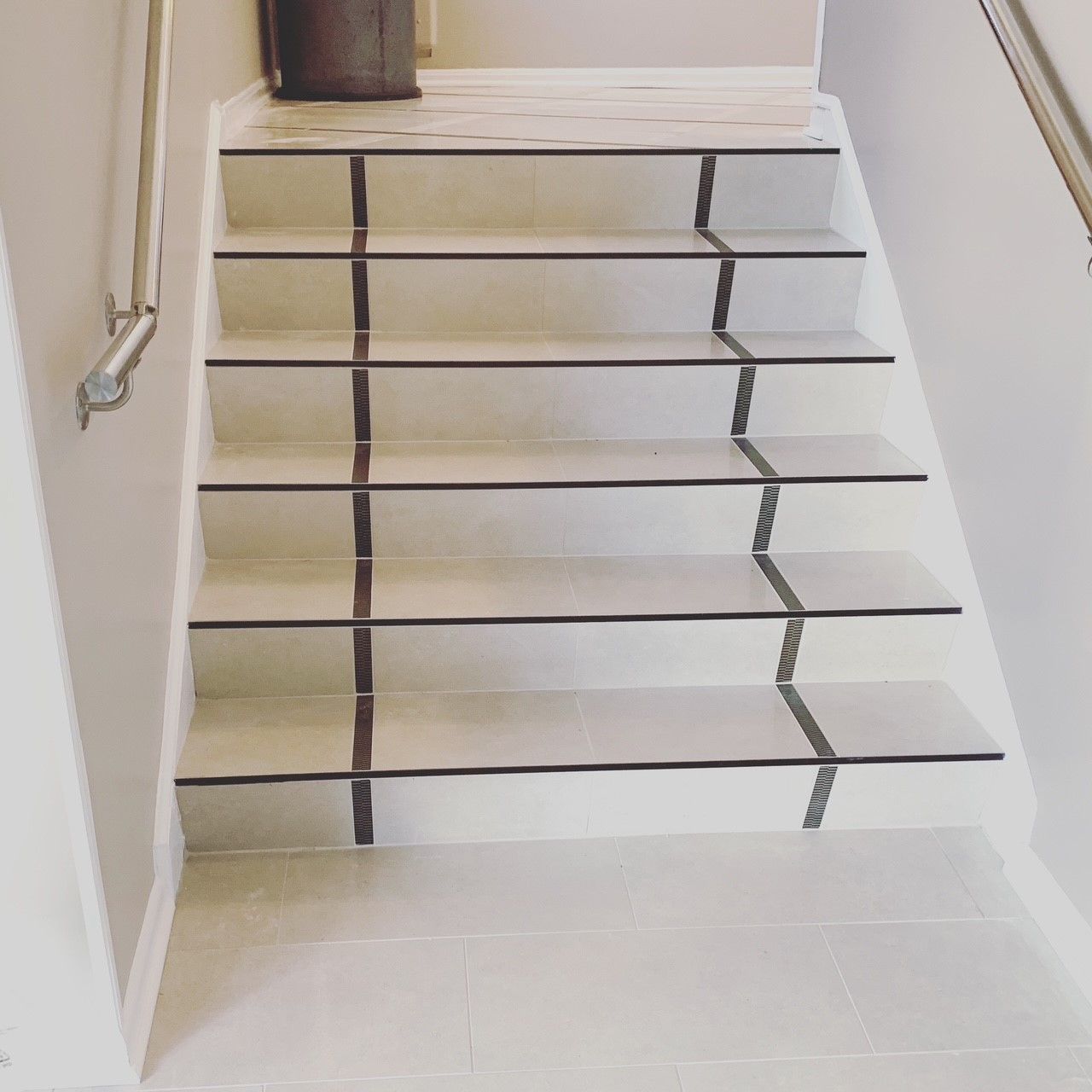 A set of white stairs with black stripes on the steps