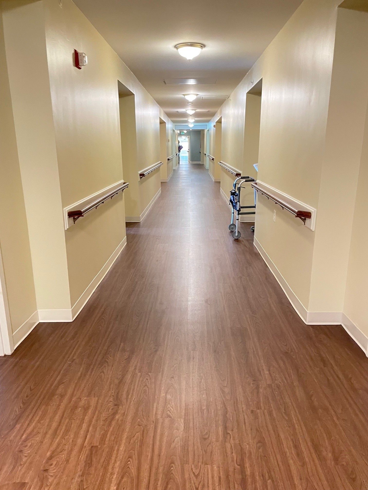 A long hallway with a walker in the middle of it.