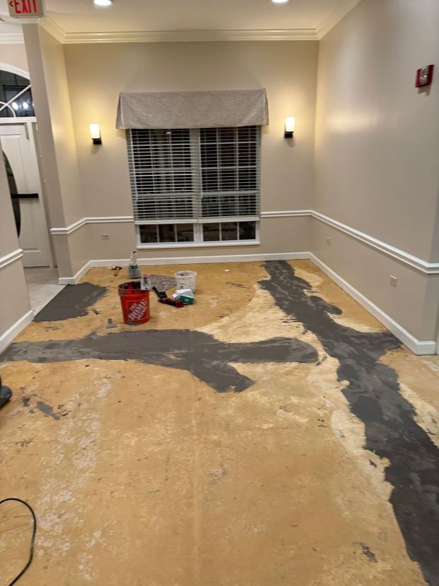 A room with a bucket and a vacuum cleaner on the floor.