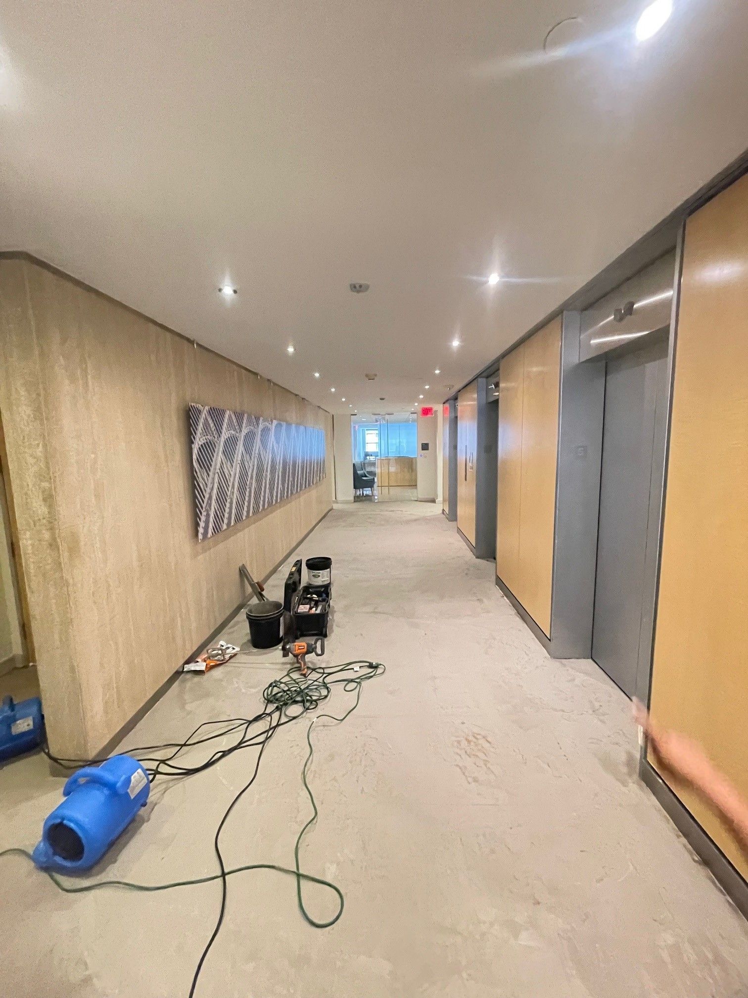 A long hallway with a vacuum cleaner on the floor.