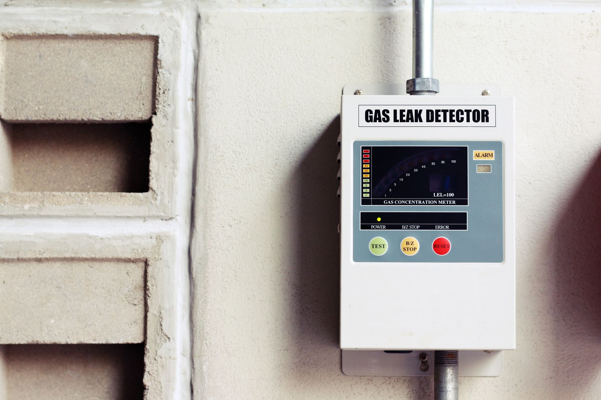 A gas leak detector is mounted on a wall