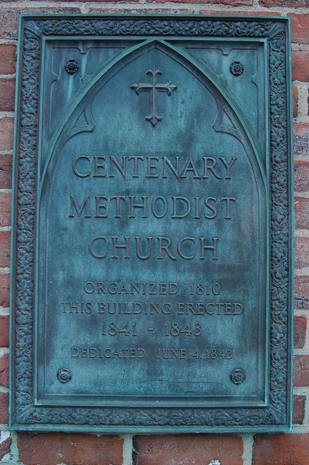a plaque on a brick wall says centenary methodist church