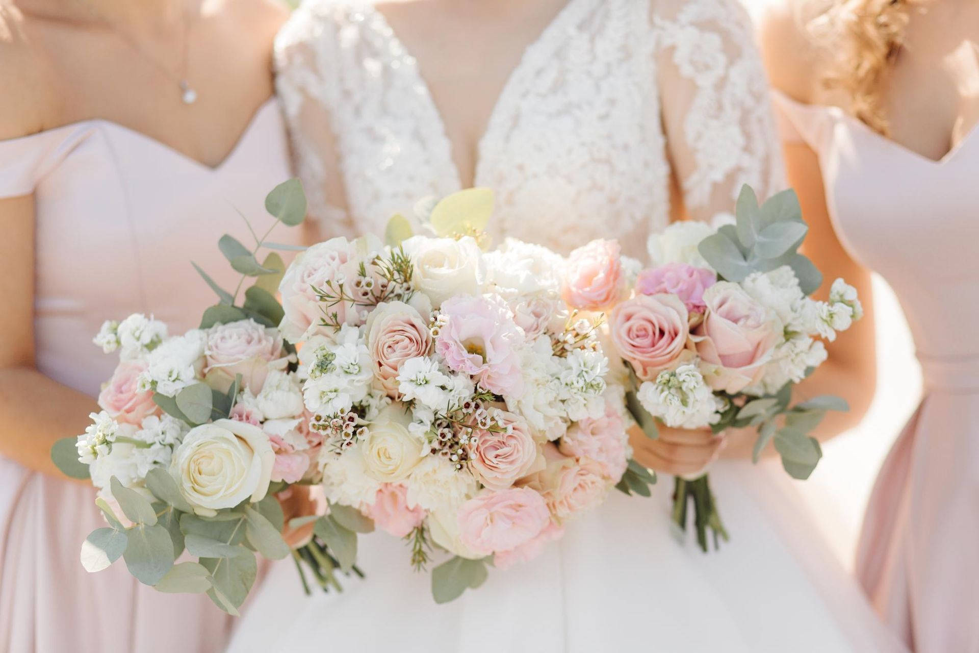 A bride and her bridesmaids are holding a bouquet of flowers.