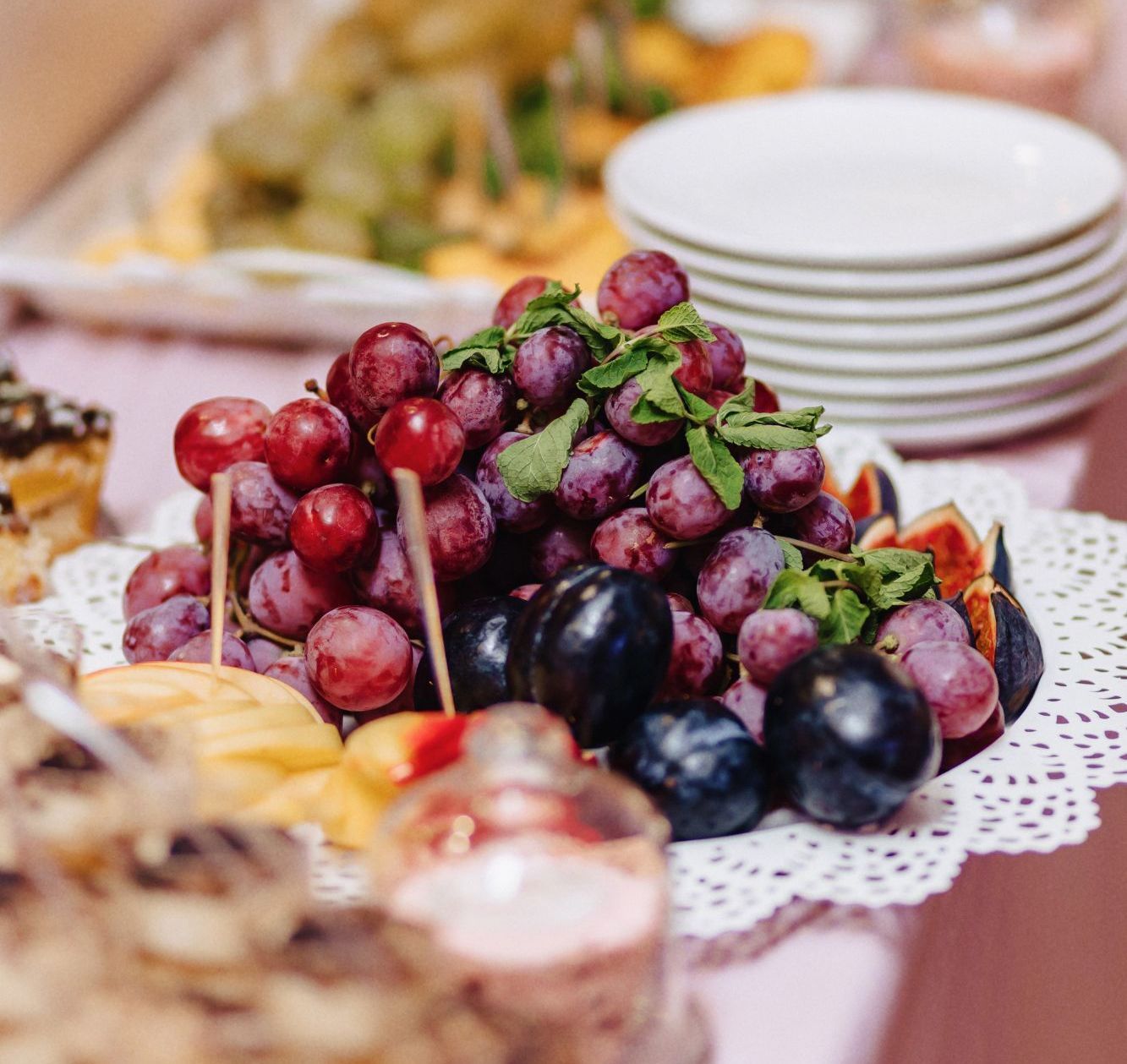 A bunch of grapes sitting on top of a plate on a table.