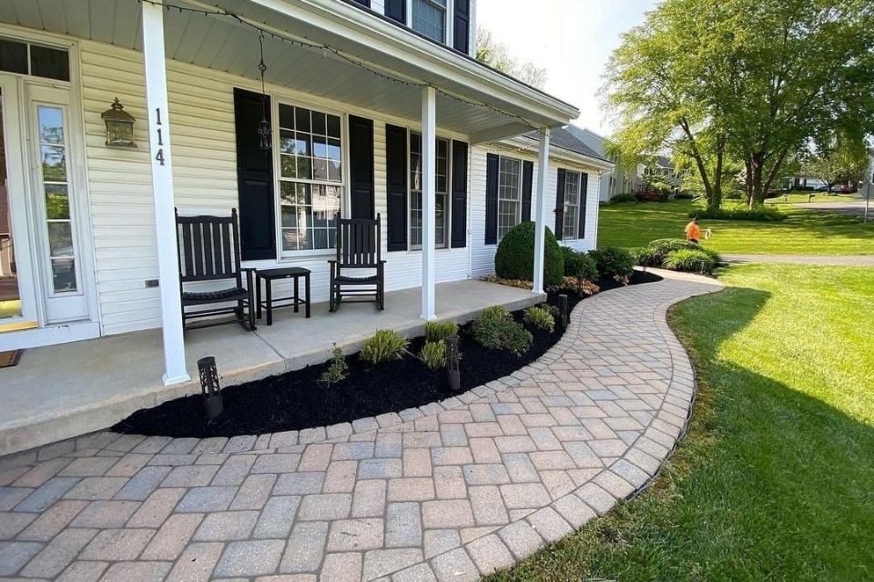 A small house is sitting in the middle of a grassy field.
