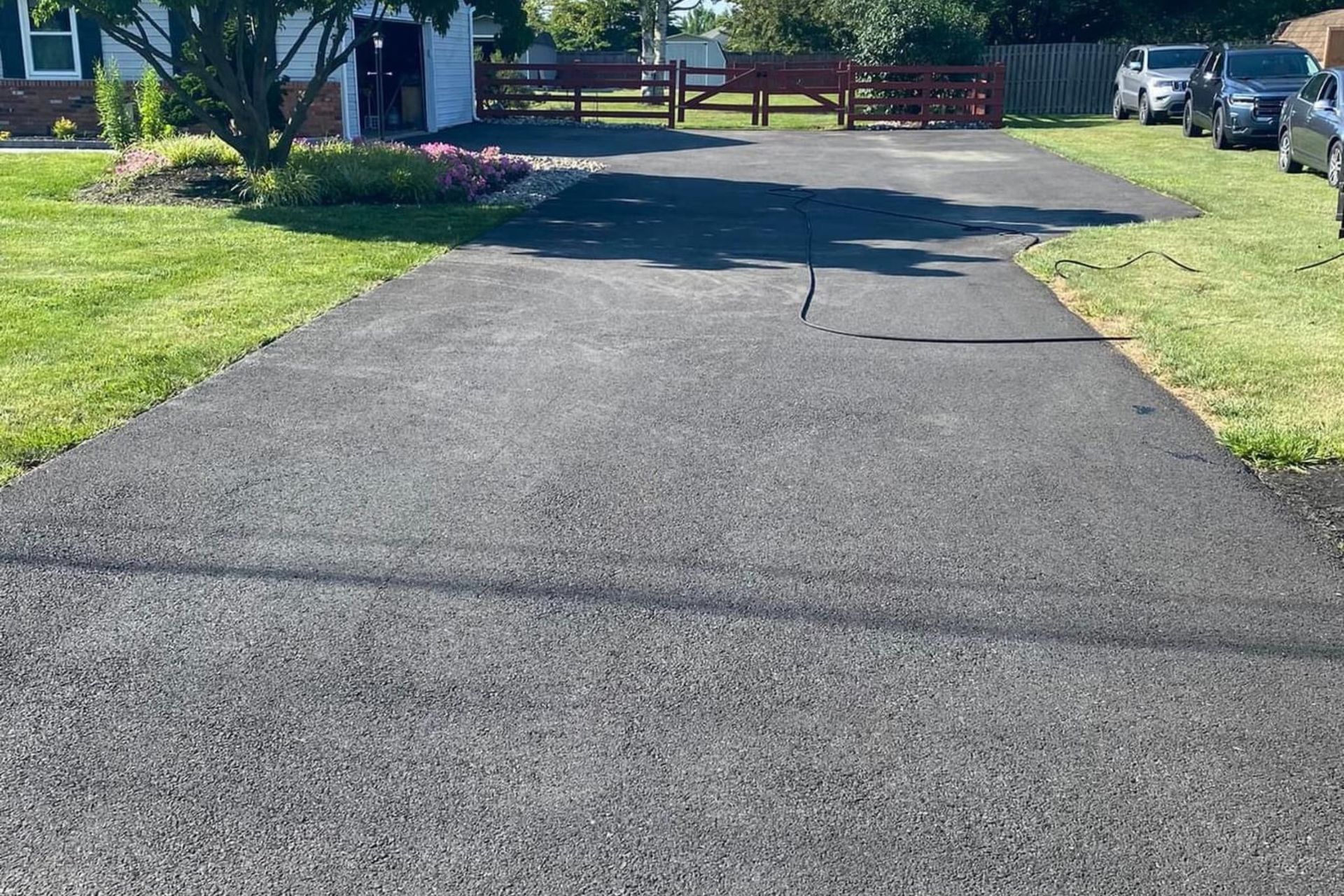 A driveway leading to a house with cars parked on the side of it.