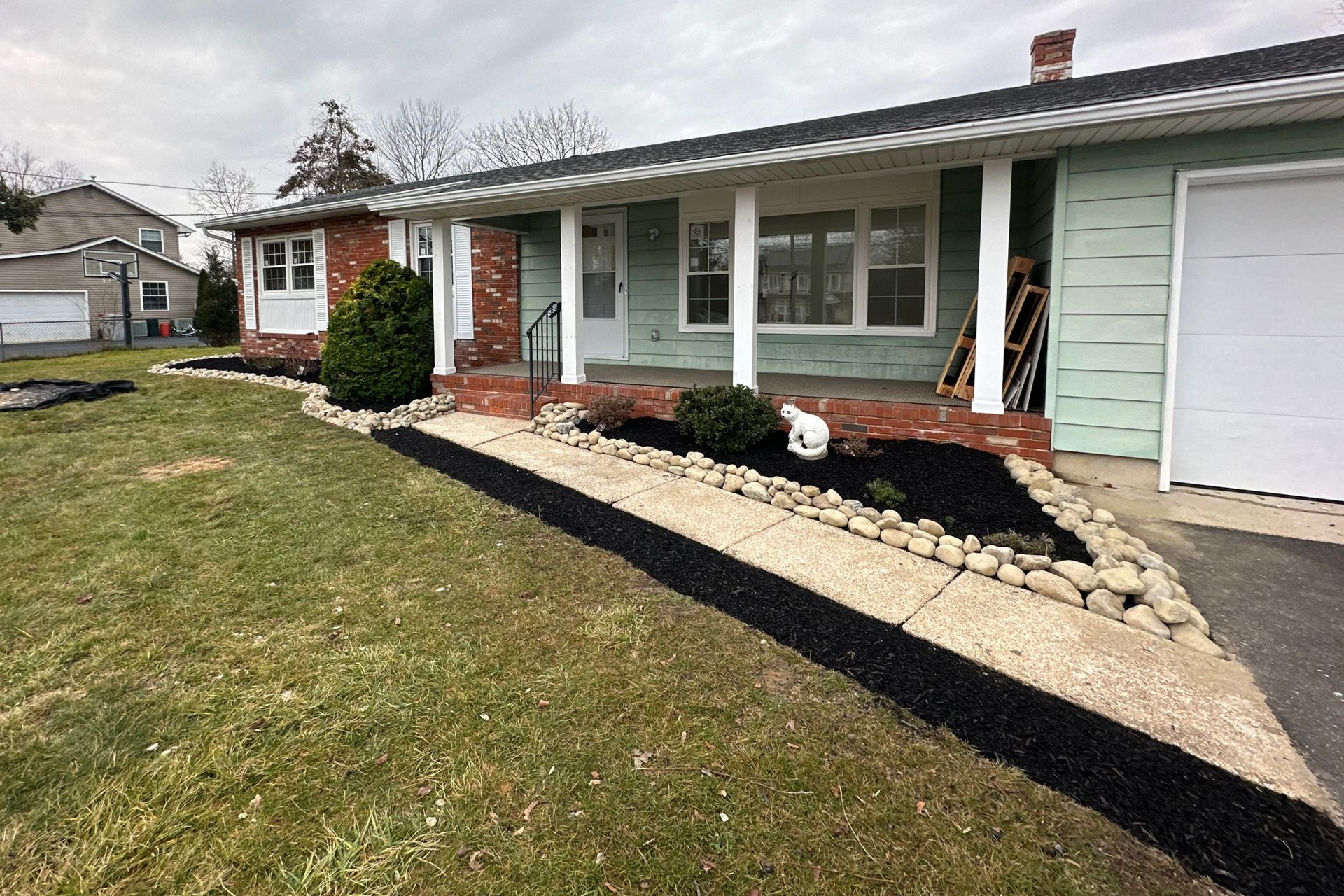 A house with a porch and a walkway in front of it.