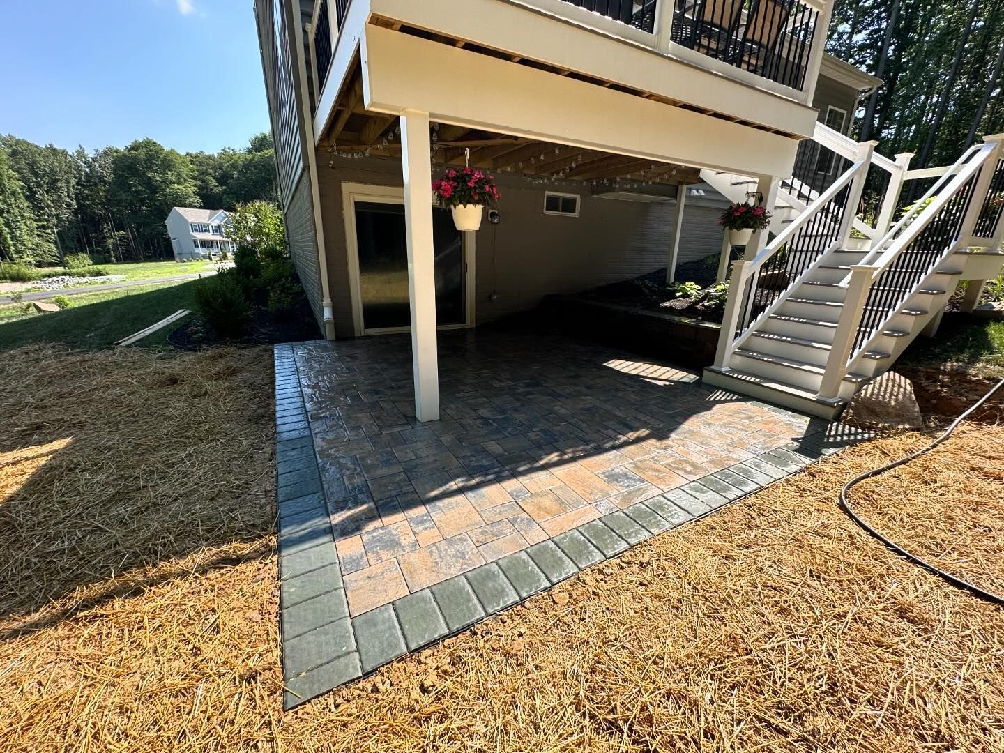 A house with a patio and stairs underneath it.