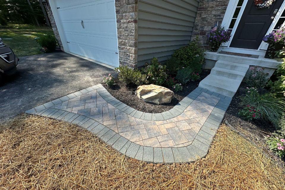 A brick walkway leading to the front door of a house.