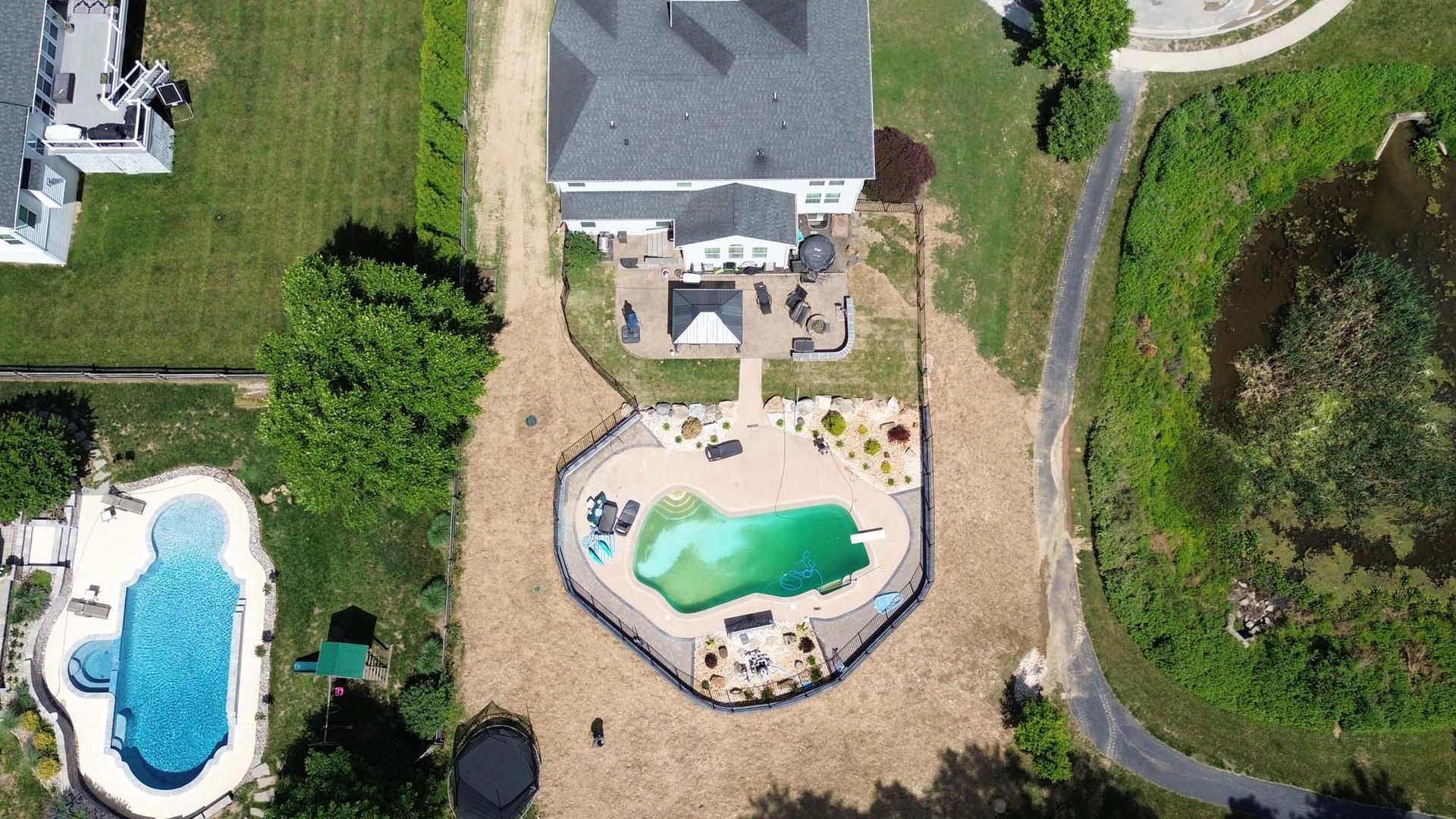 An aerial view of a house with a large pool in the backyard