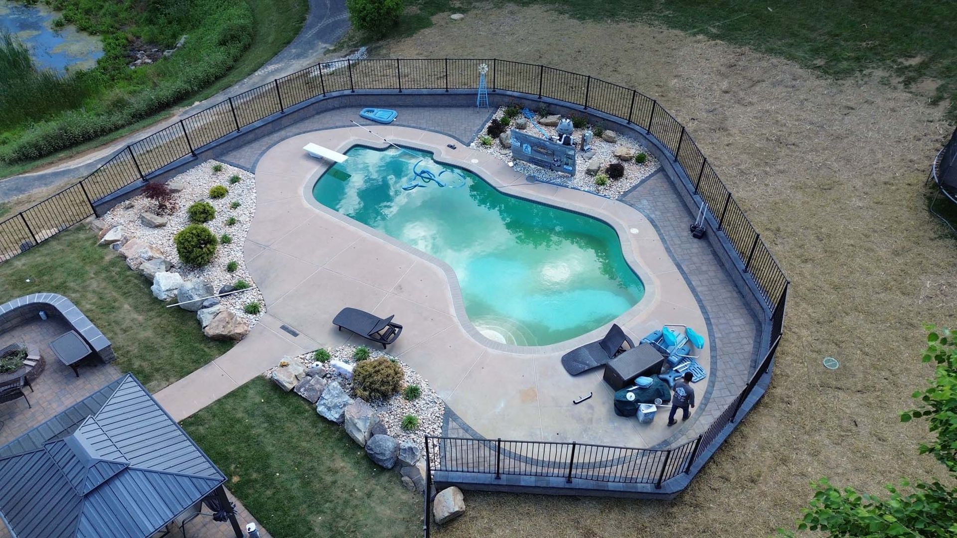 An aerial view of a swimming pool surrounded by a fence.