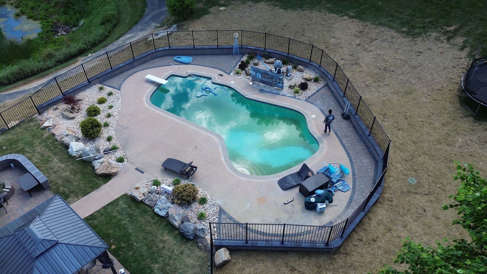 An aerial view of a large swimming pool surrounded by a fence.