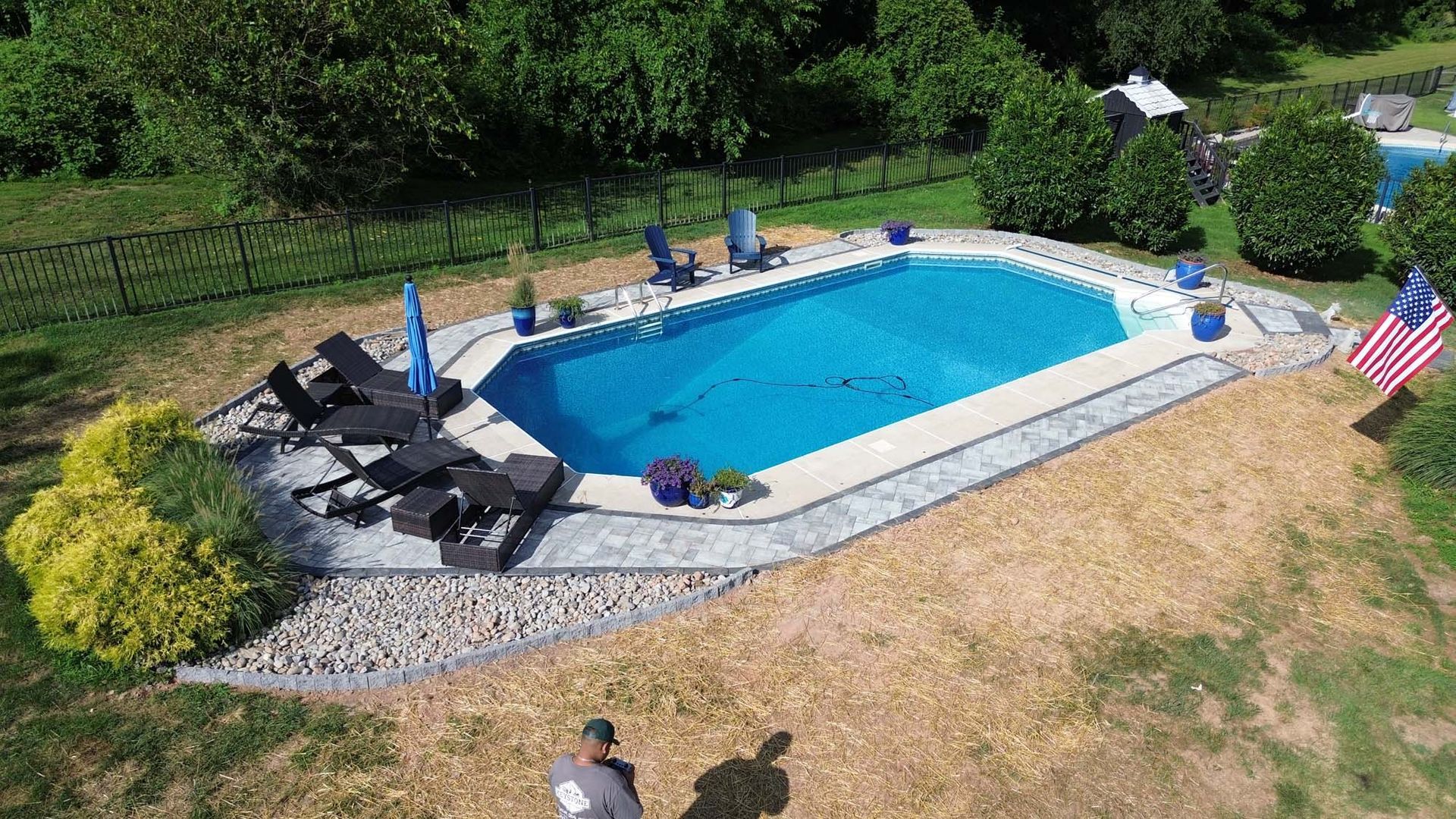 An aerial view of a swimming pool surrounded by chairs and umbrellas.