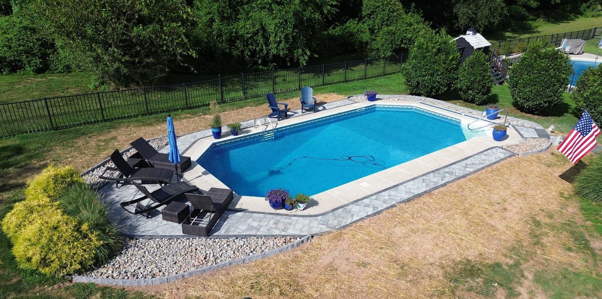 A stone walkway is being built in the backyard of a house.
