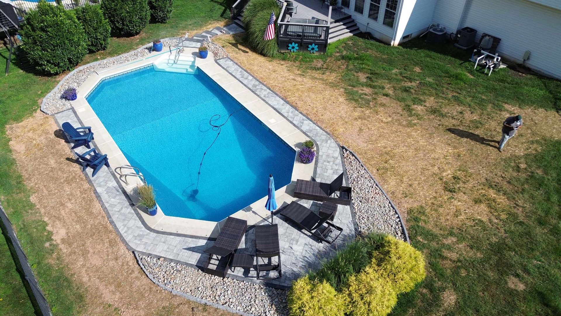An aerial view of a large swimming pool in a backyard.