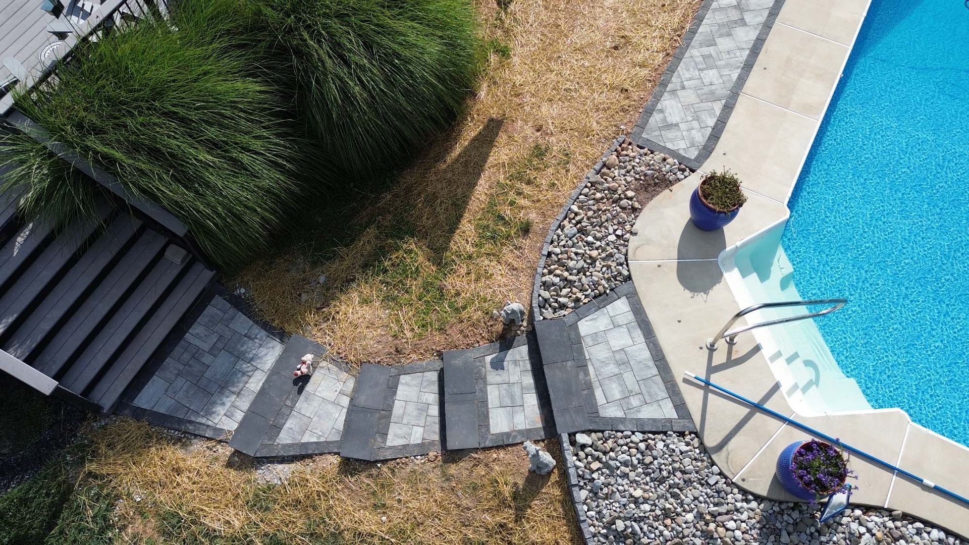An aerial view of a swimming pool with stairs leading to it.