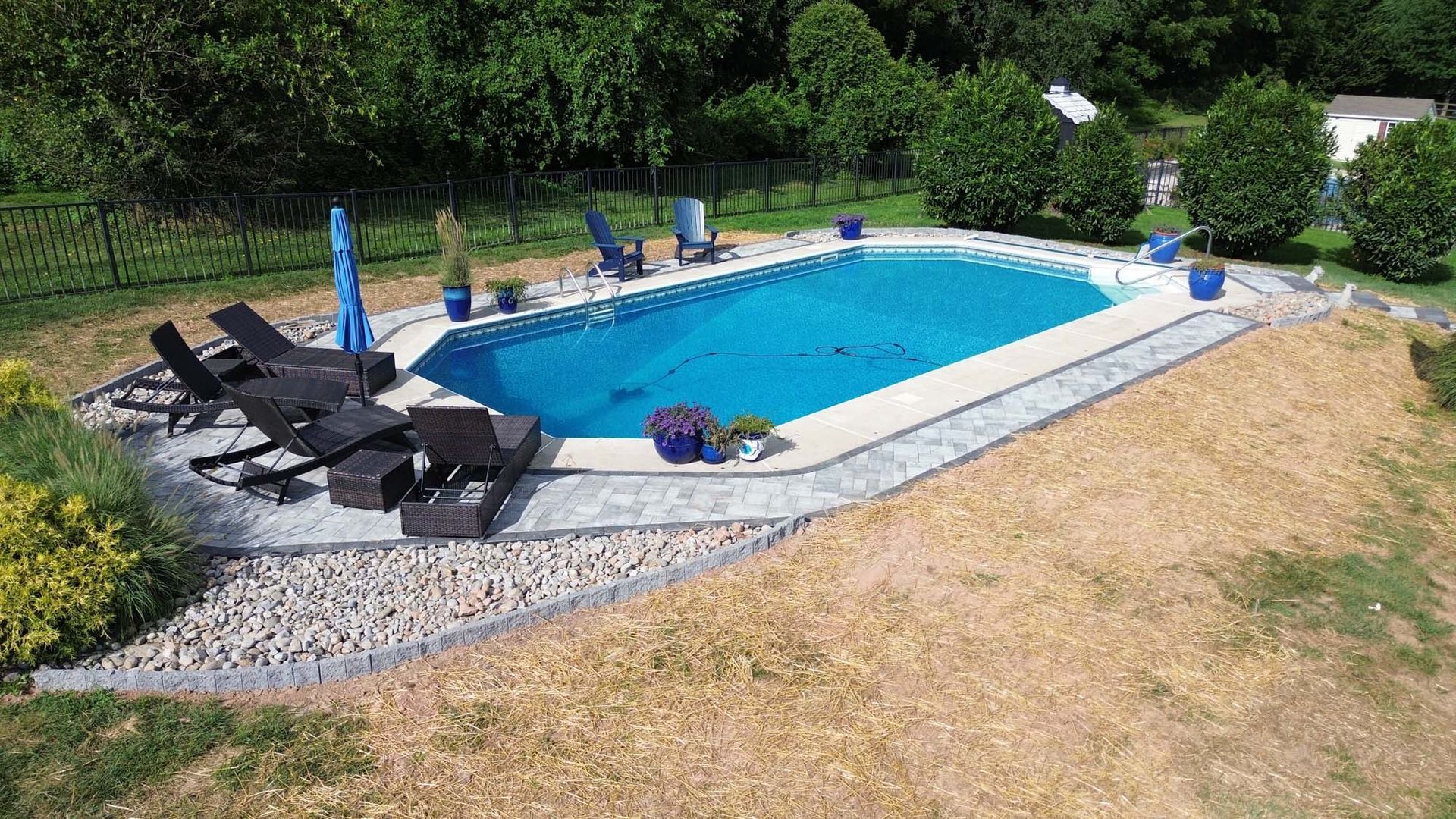 An aerial view of a large swimming pool surrounded by chairs and umbrellas.