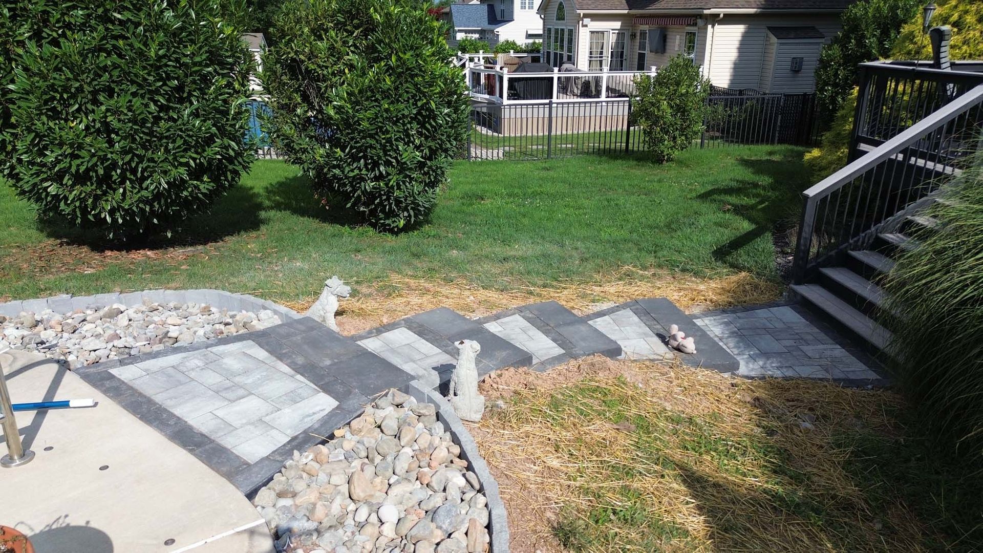 A stone walkway is being built in the backyard of a house.