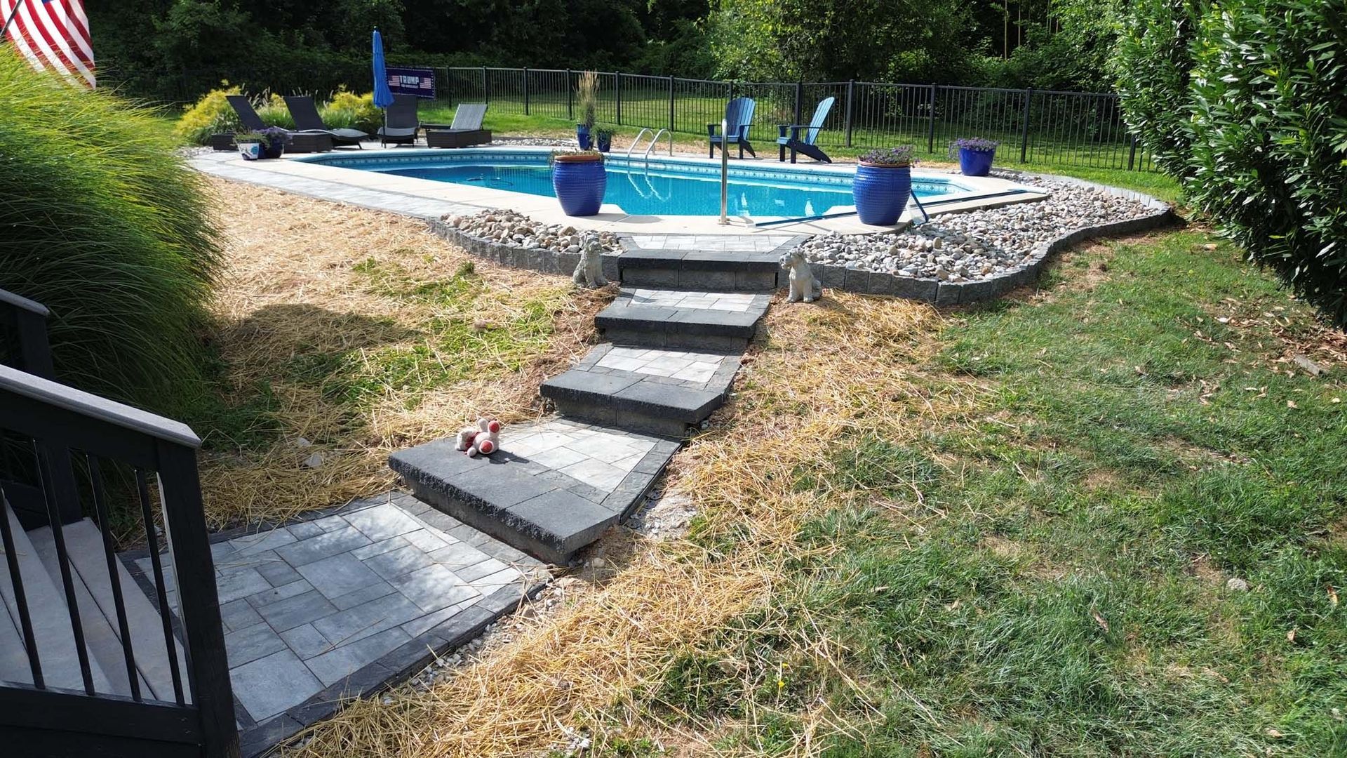 A swimming pool in a backyard with stairs leading to it.