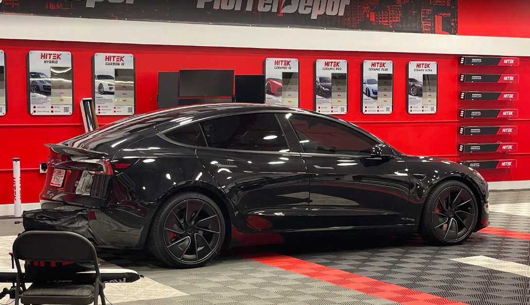 White Audi A7 parked inside a shop; Texas license plate; taillights lit.