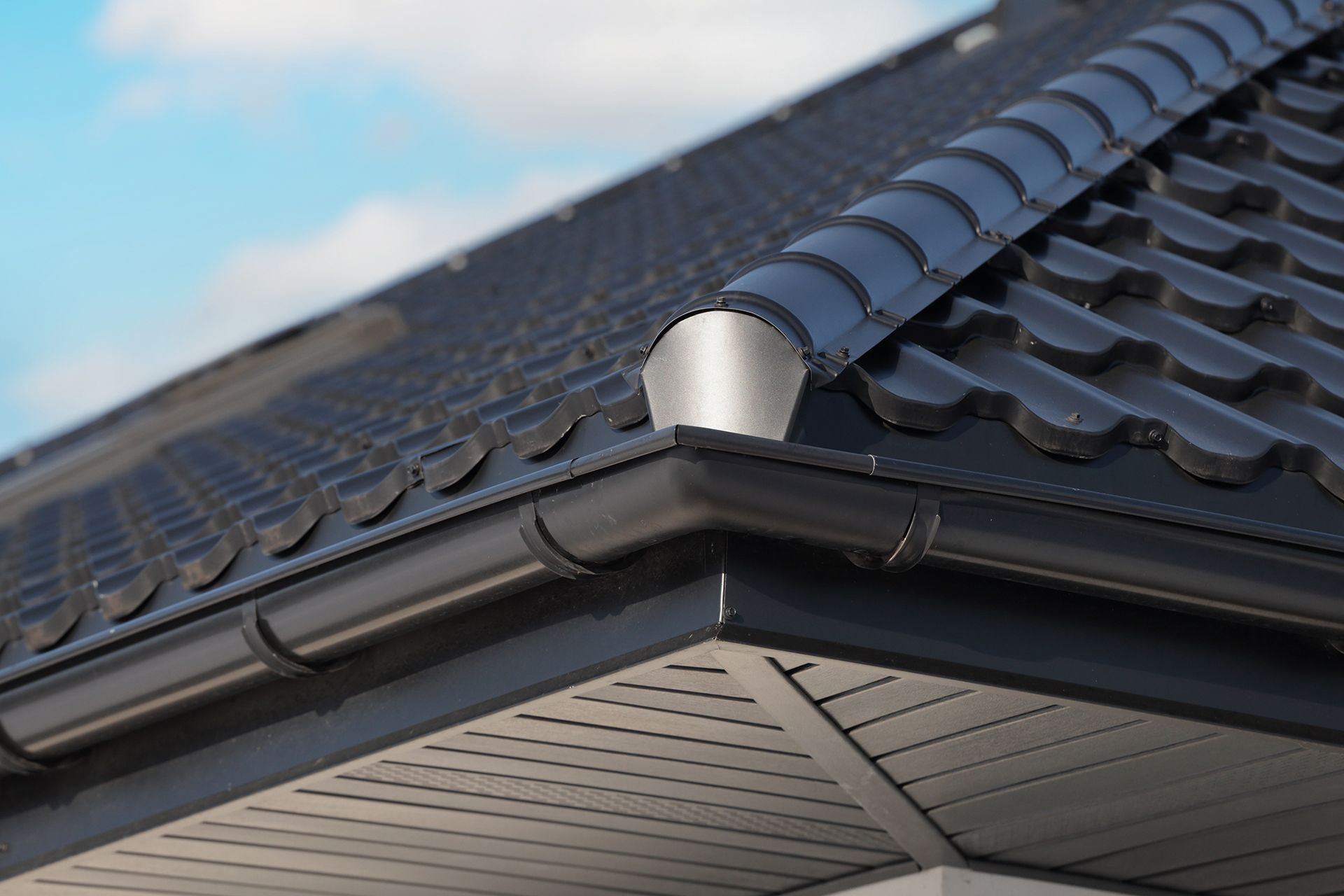 A close up of a gutter on a roof of a house.