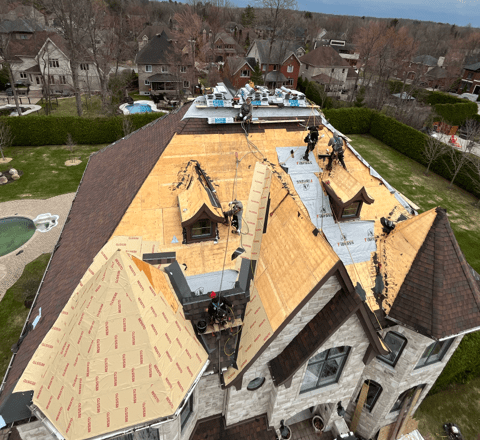 Une vue aérienne d'une grande maison avec un toit en cours d'installation