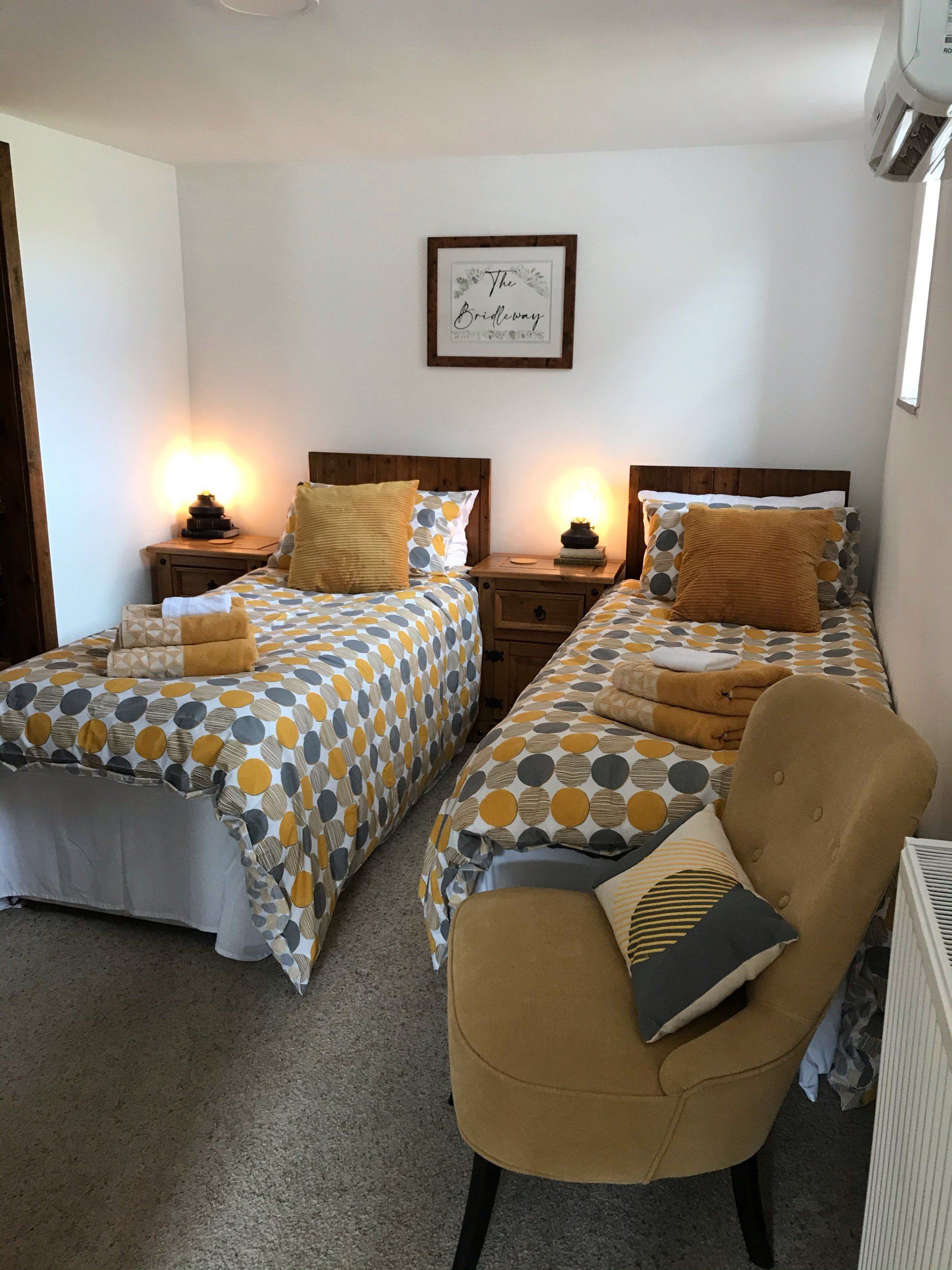 2 single beds with yellow and grey bedspreads