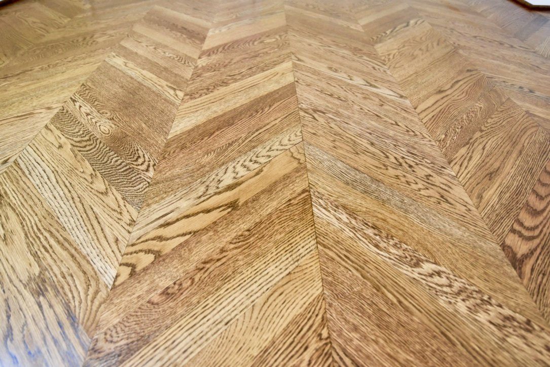 A close up of a wooden floor with a herringbone pattern