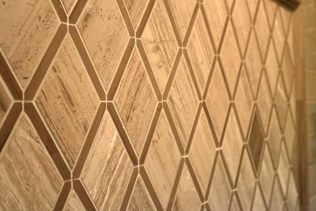 A close up of a tile wall with a diamond pattern