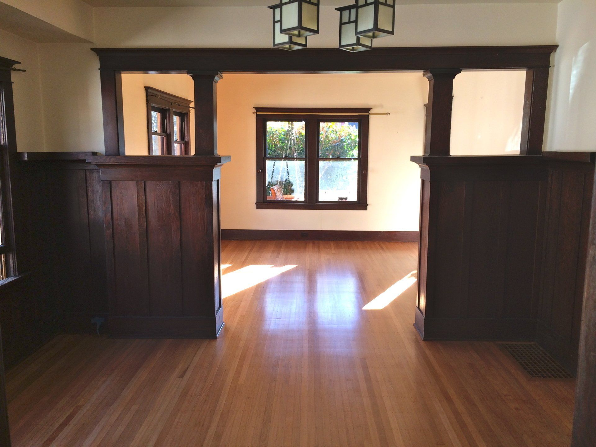 An empty room with hardwood floors and a window
