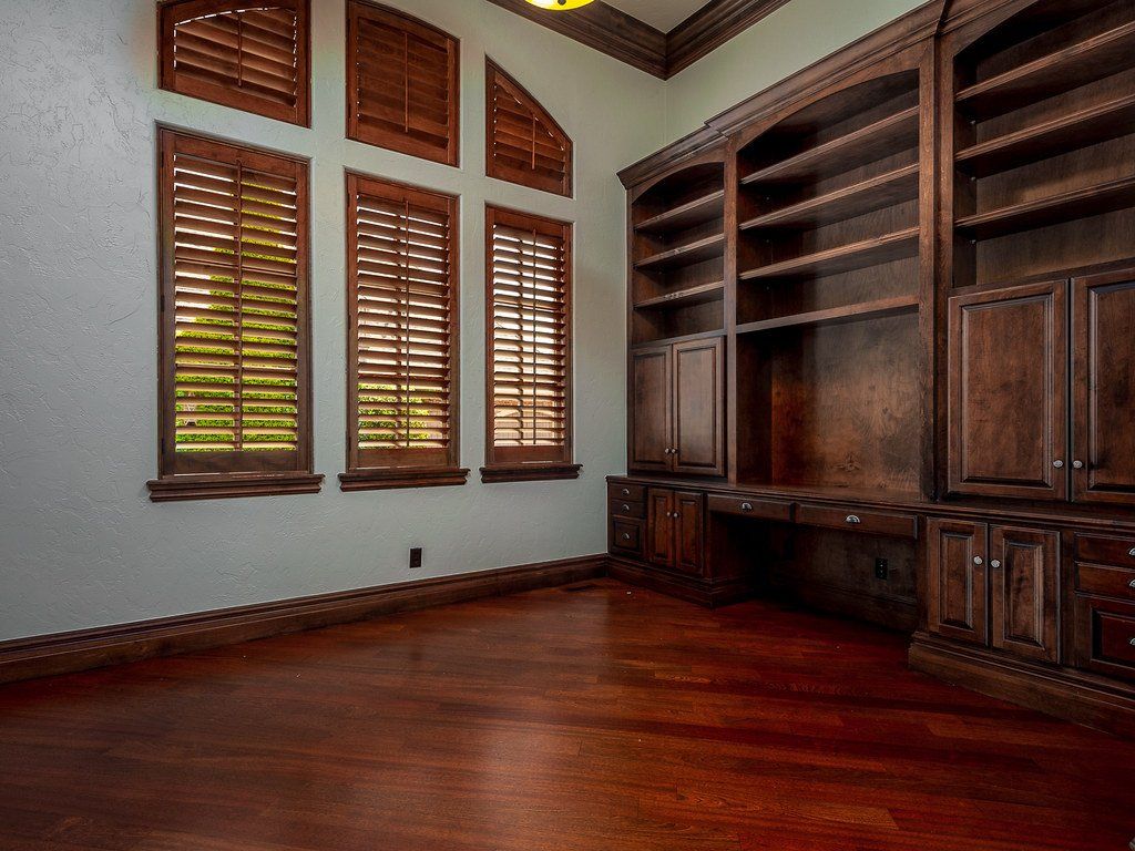 A room with wooden cabinets and shutters on the windows