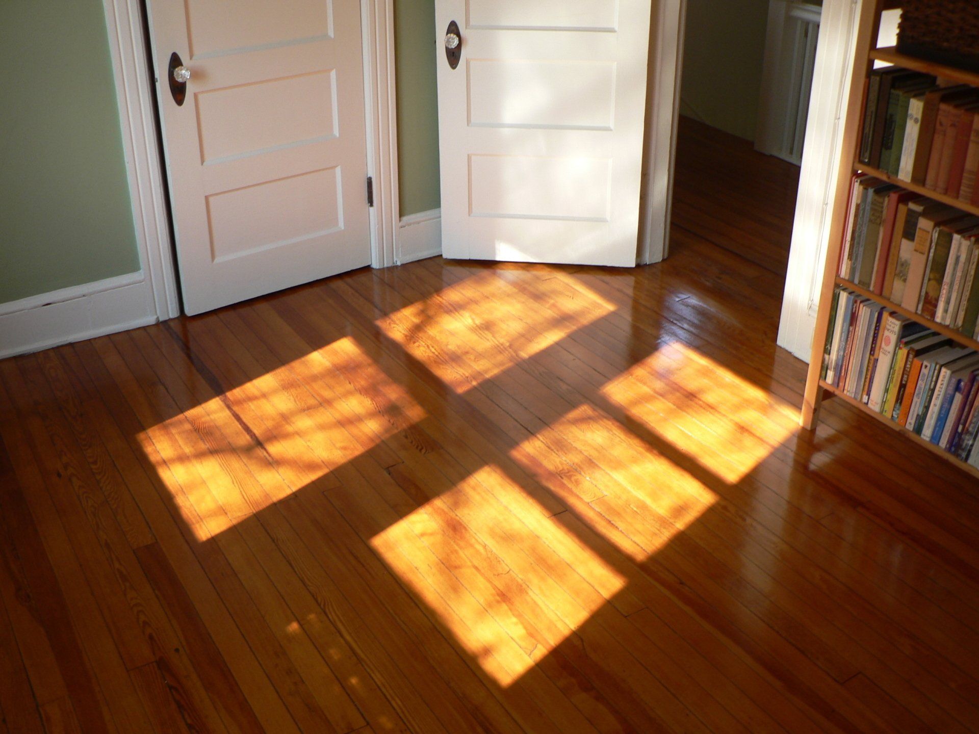 The sun shines through the windows on the hardwood floor
