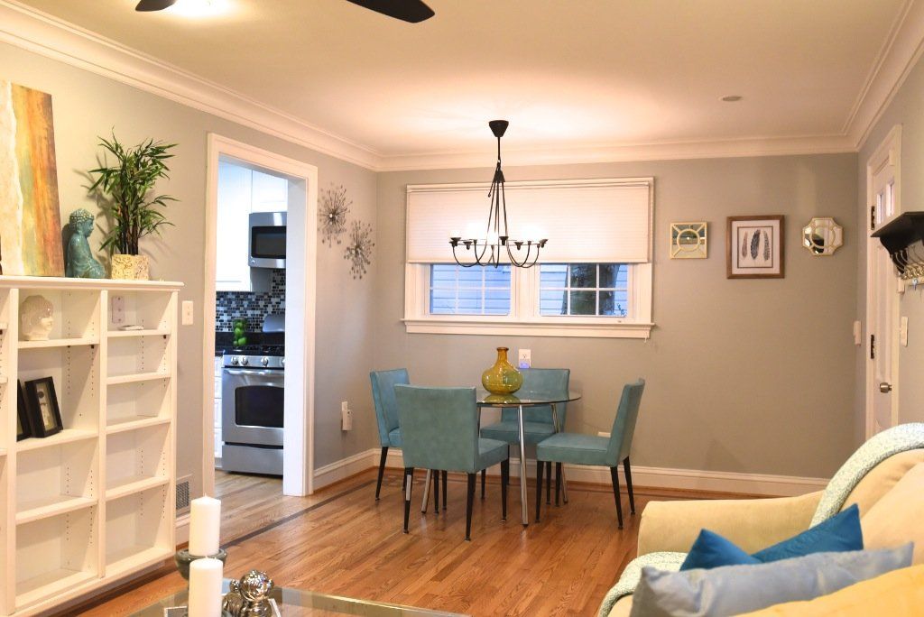 A living room with a table and chairs and a ceiling fan