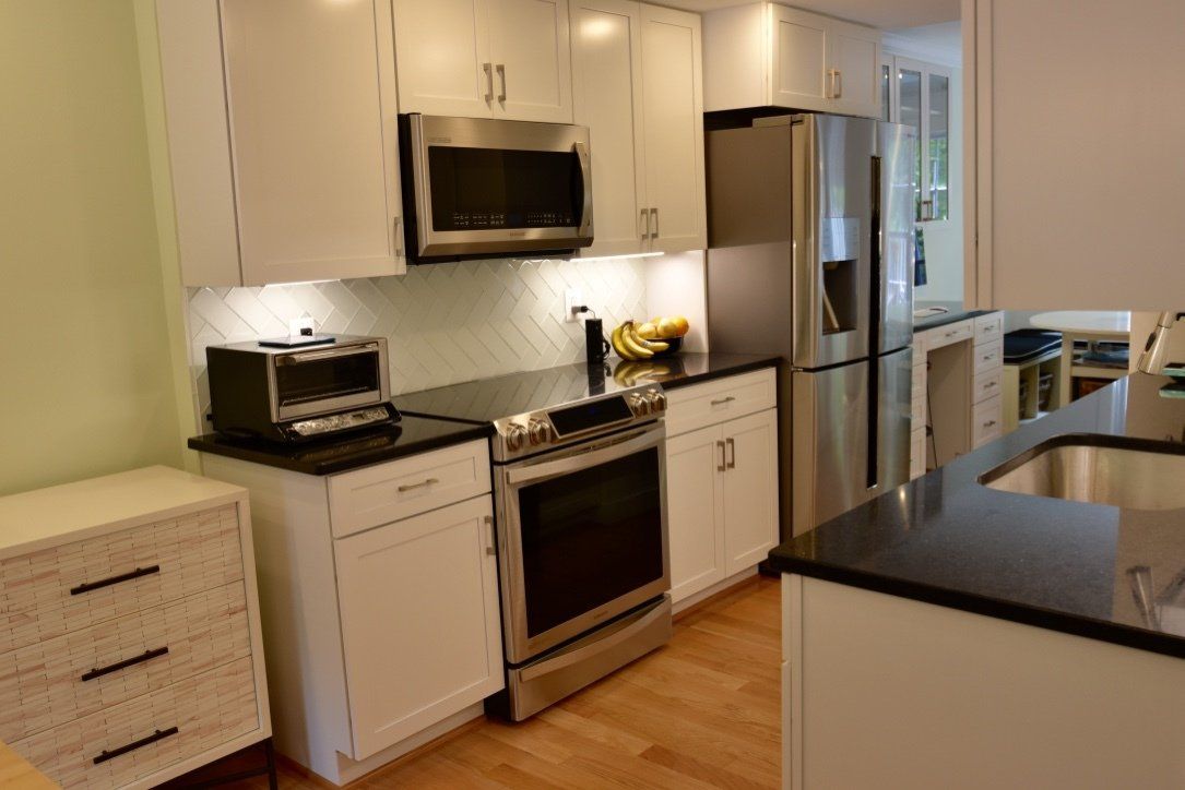 A kitchen with stainless steel appliances and white cabinets