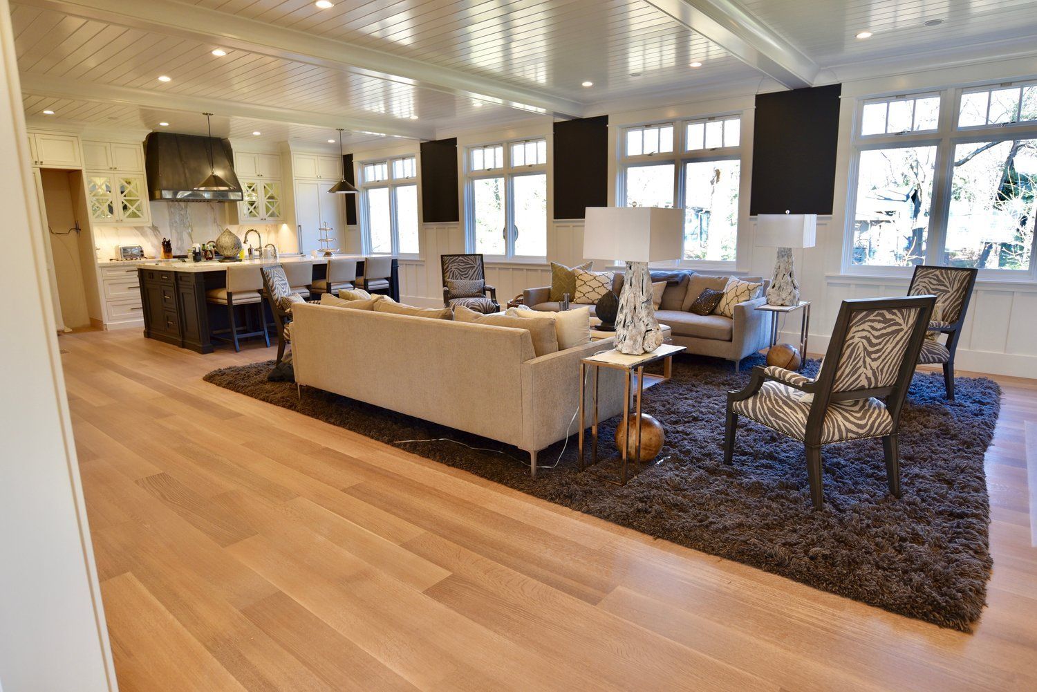 A living room with a couch and chairs and a rug