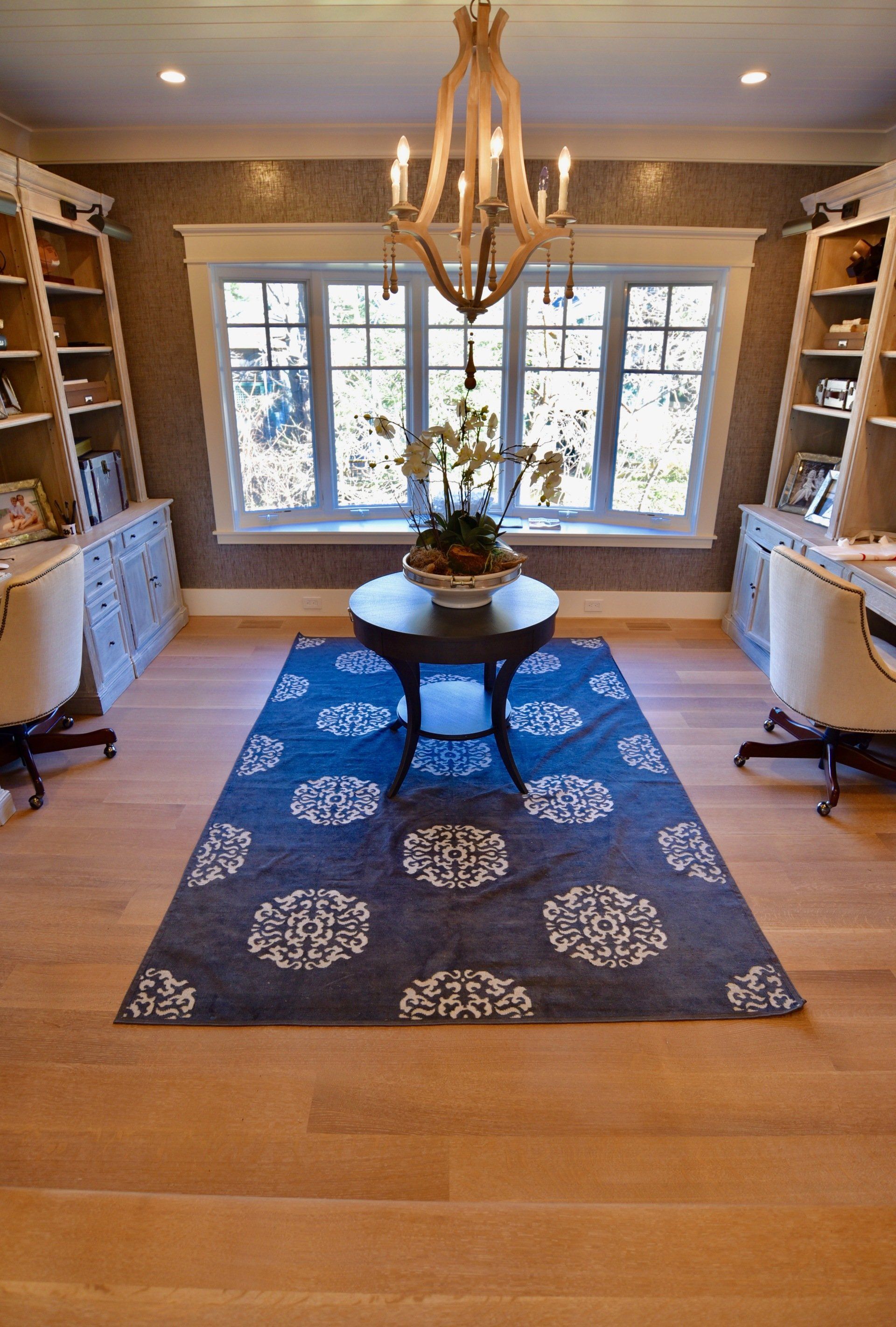 A room with a blue rug and a chandelier