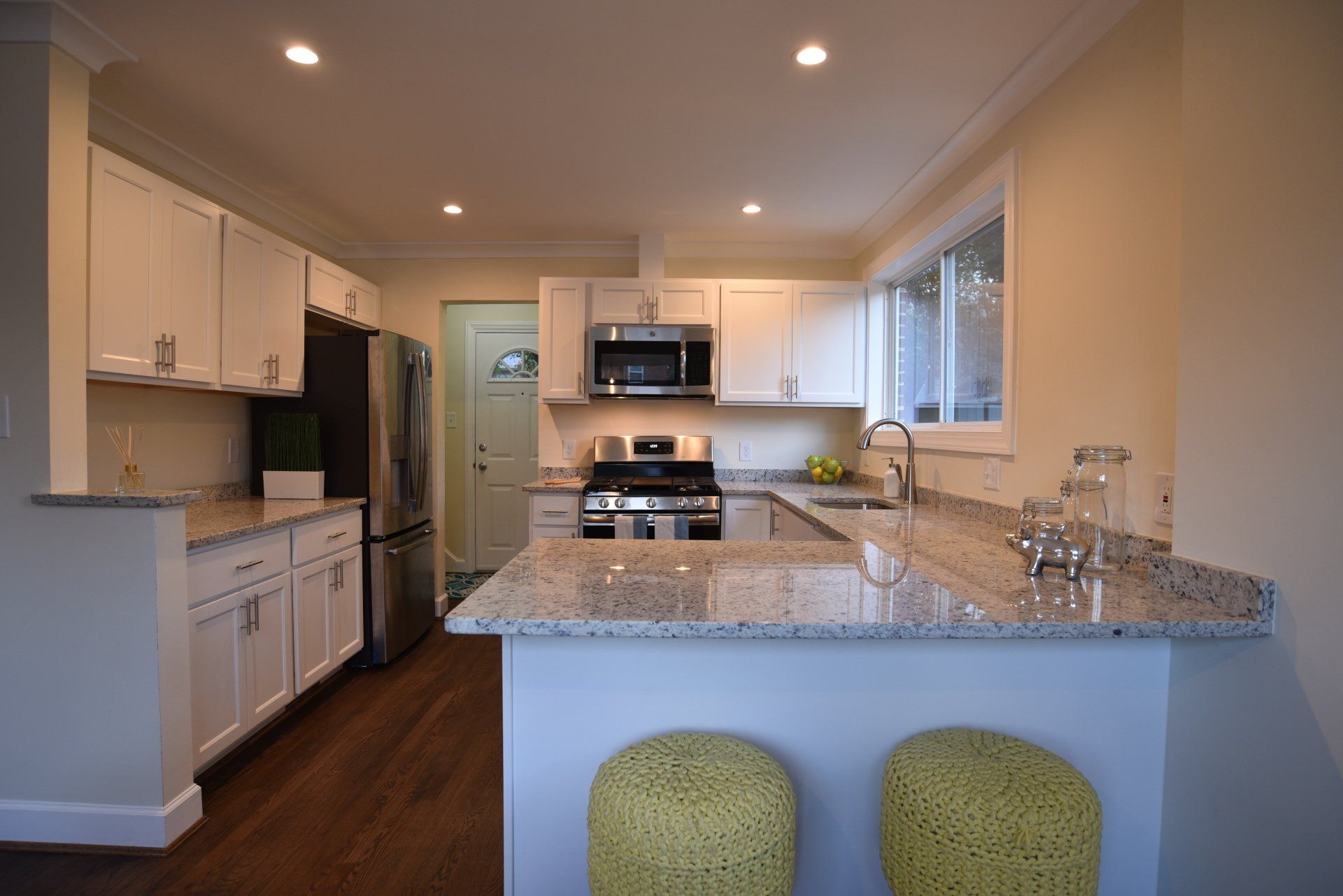 A kitchen with granite counter tops and white cabinets